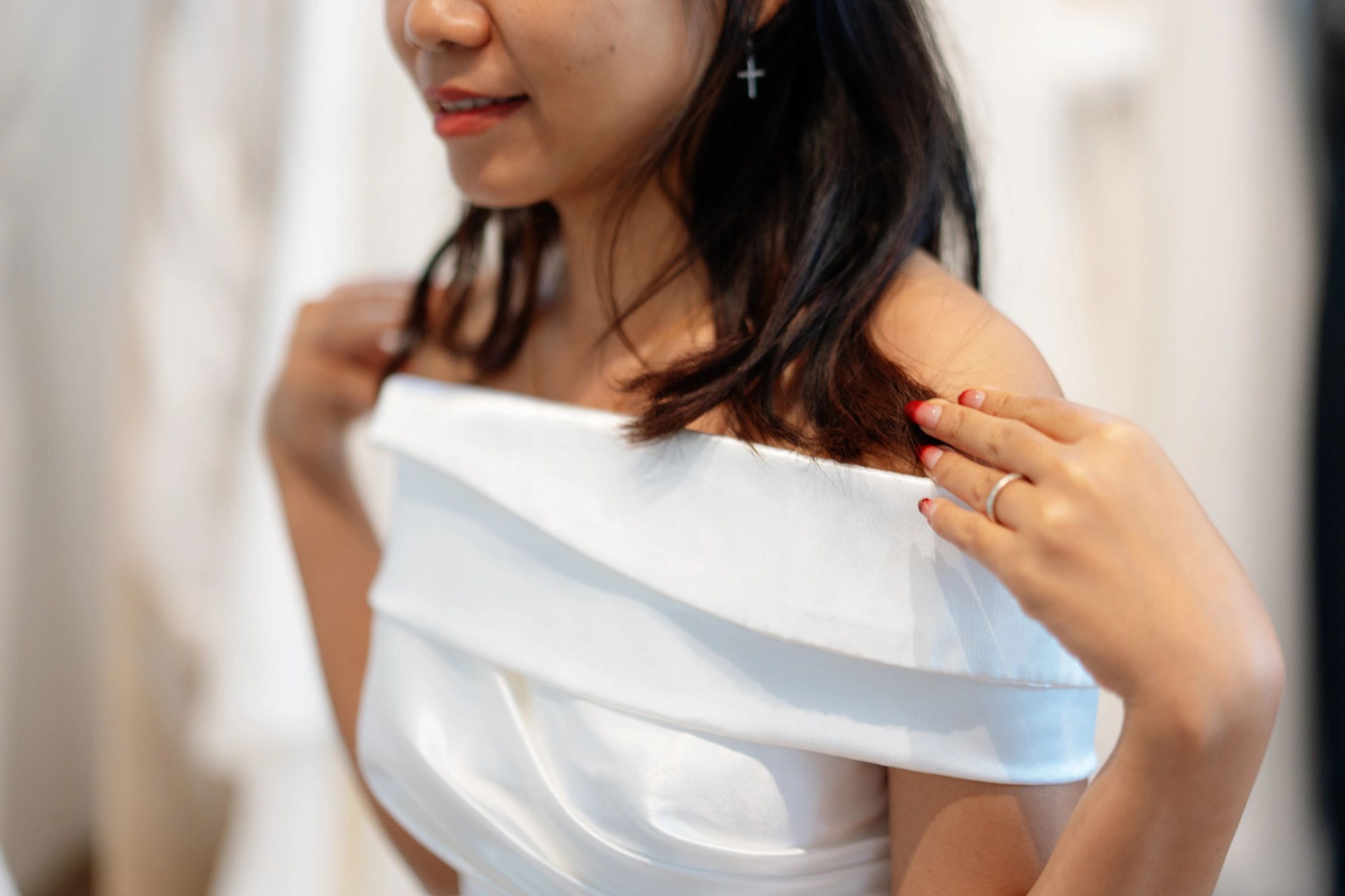 Bride adjusting a satin dress in a boutique